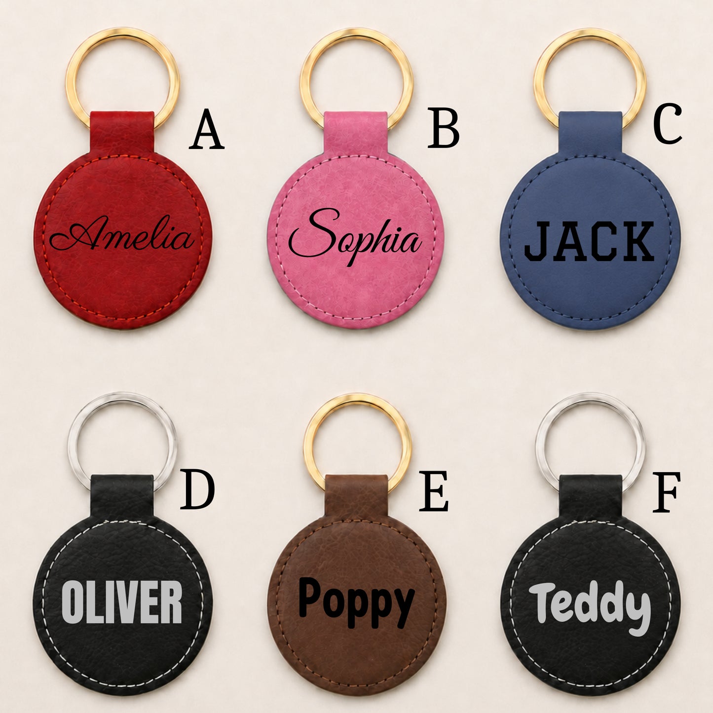 Six personalized round keychains arranged in a 2x3 grid on a light beige background. Each keychain has a stitched leather oval tag with a gold-tone or silver-tone key ring and a custom name or text printed on it.
