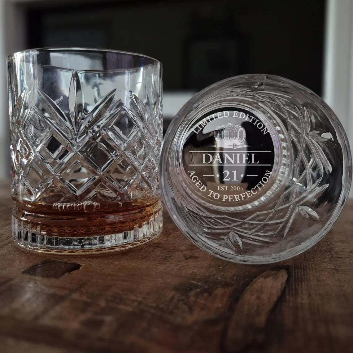 Crystal glass with engraved design on a wooden surface